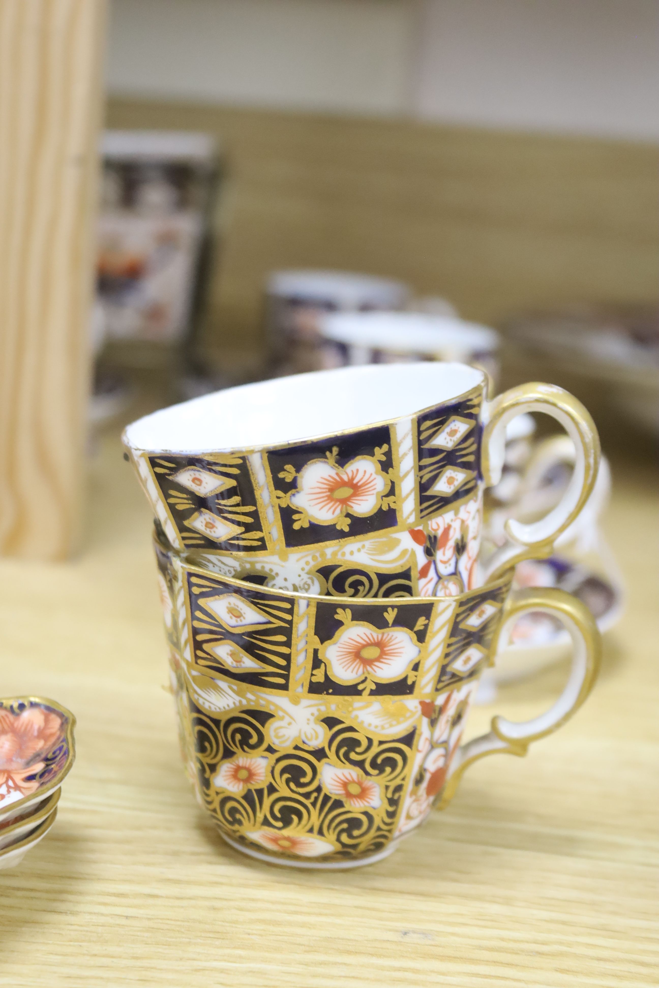 A collection of Royal Crown Derby Imari patterned ceramics including cups, side plates and platter